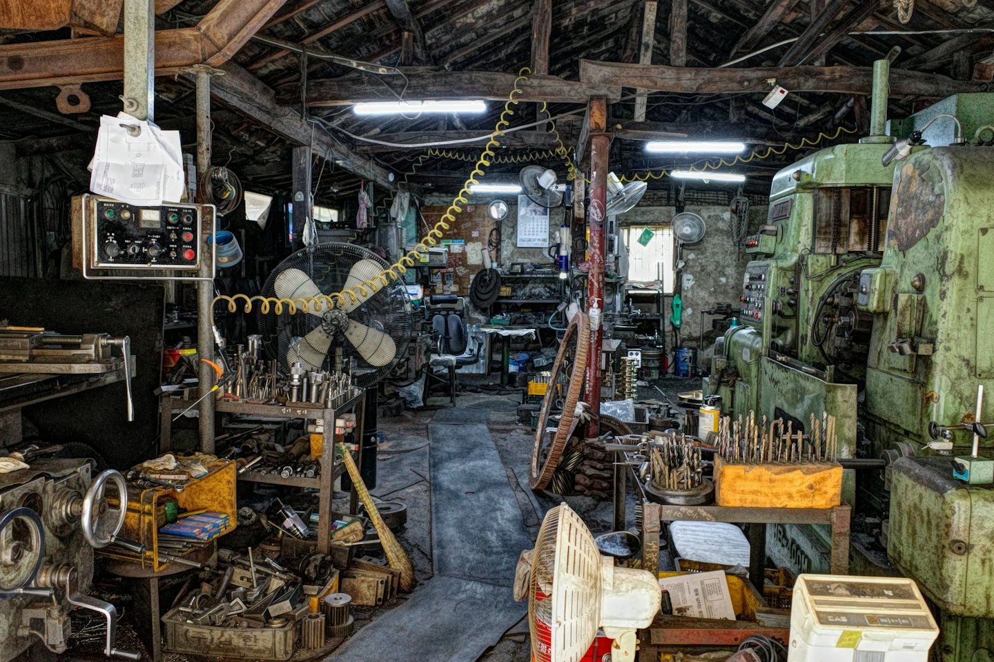 Officina industriale rustica e disordinata con macchinari e attrezzi d'epoca.