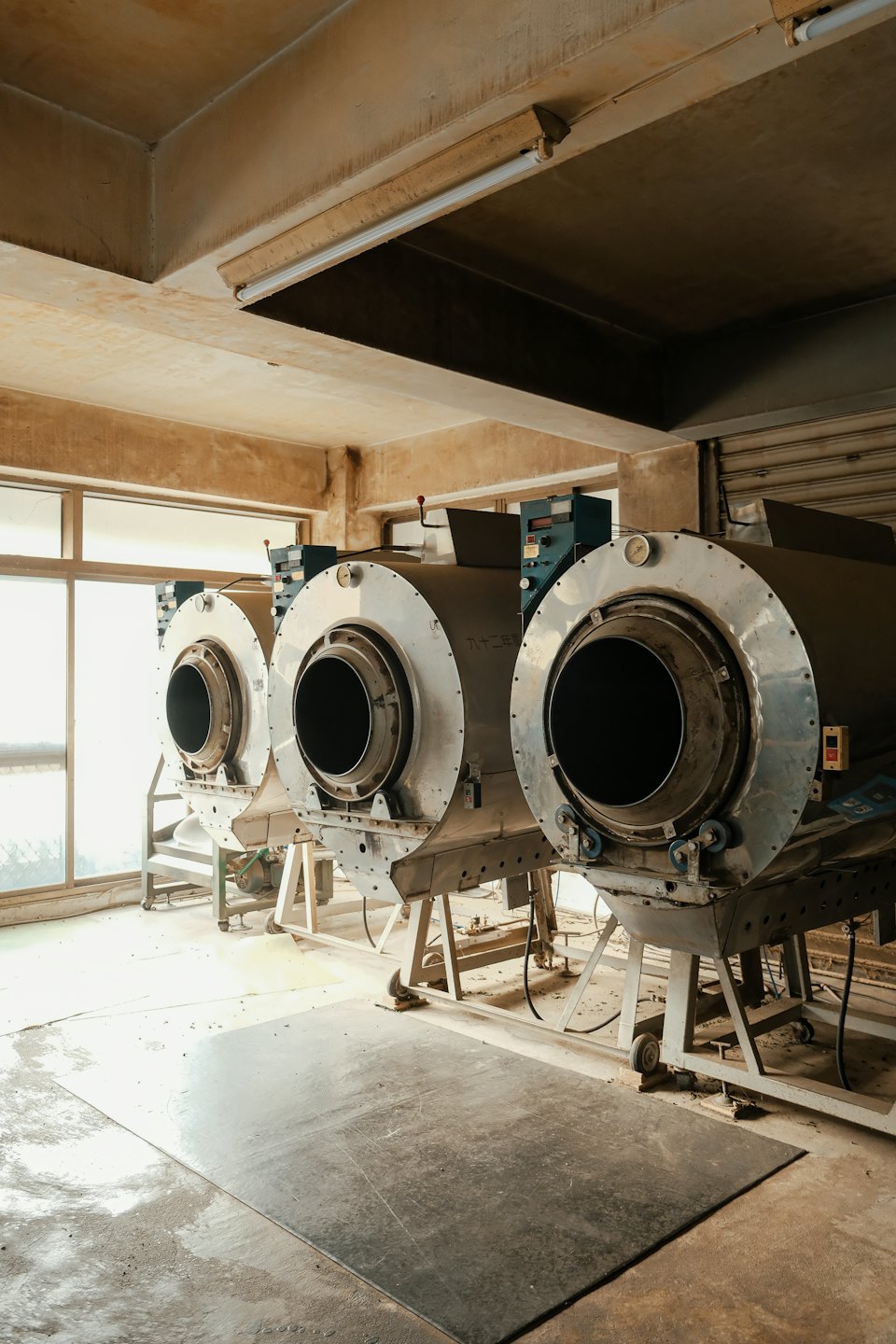 Tre macchinari industriali allineati in una fabbrica.